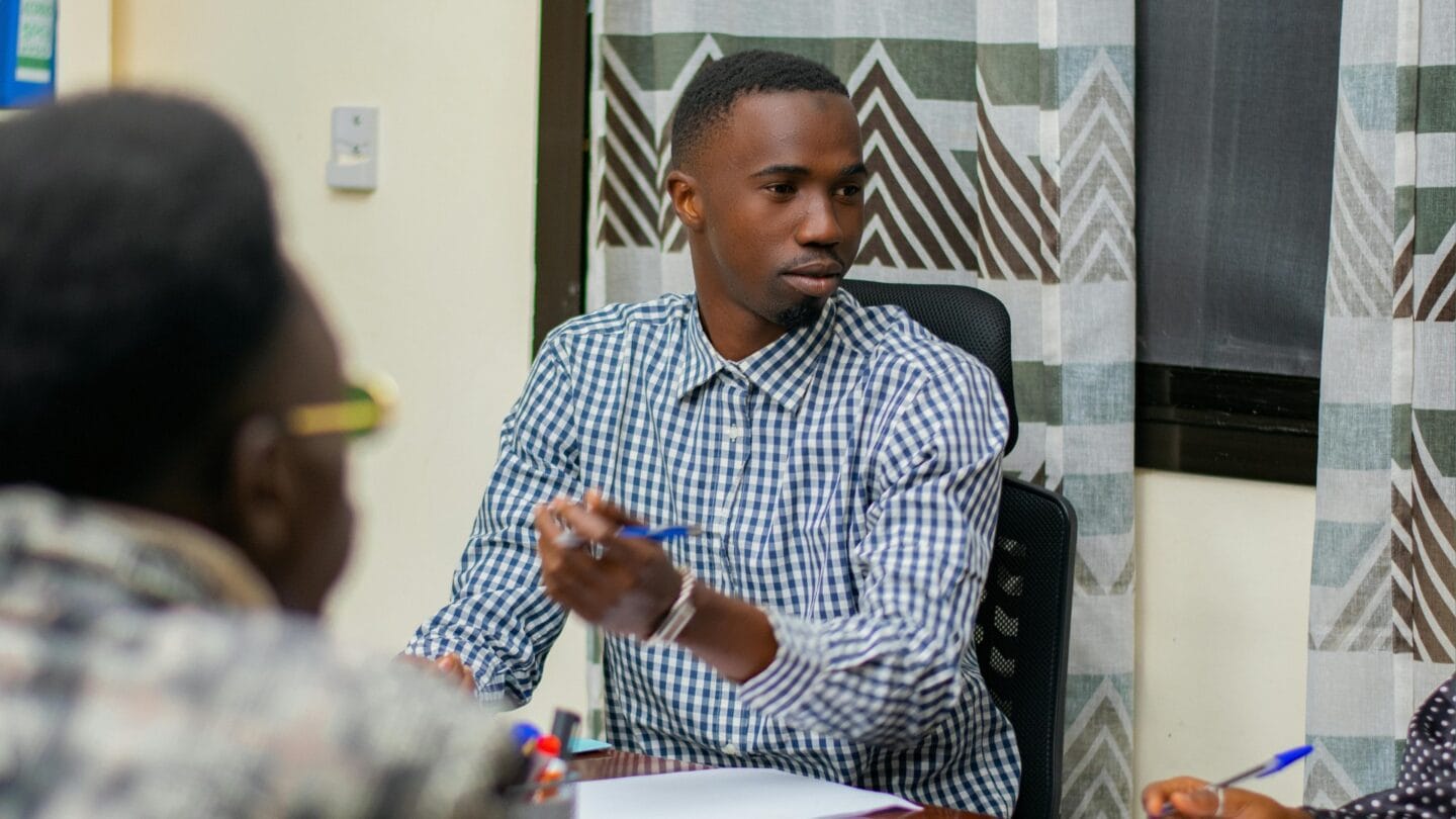 Man sitting at conference room table engaged in a discussion.
