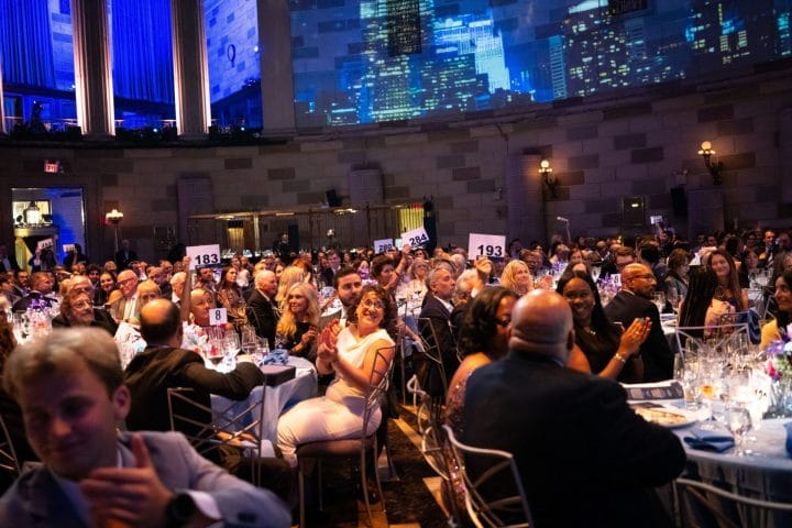 Gala attendees participating in the Fund A Coach paddle raise